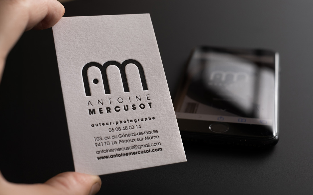 Carte imprimée en letterpress près d’un iPhone, identité visuelle du photographe Antoine Mercusot